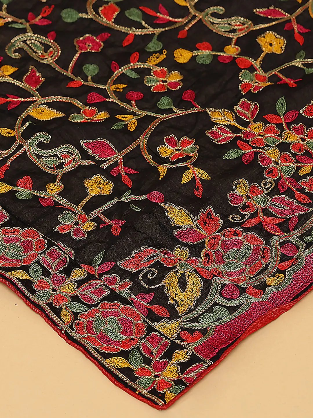 Close-up of black dupatta's colorful resham thread embroidery.
