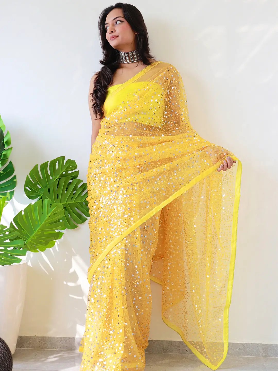 Model in yellow sequined net saree, elegant pose