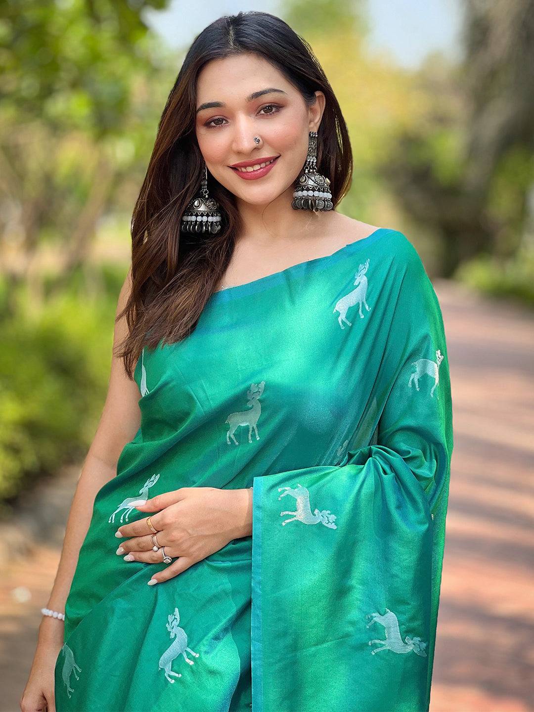 Model in green soft silk saree with zari pallu, outdoor setting