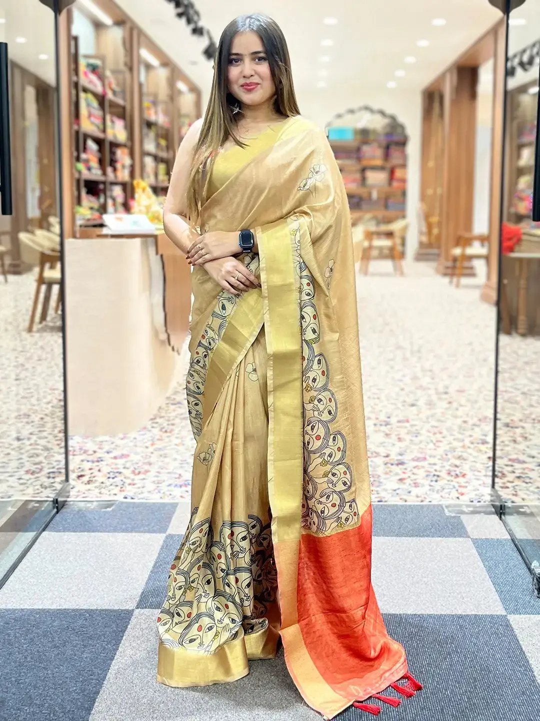 Model showcasing Gold Kalamkari Linen Tissue Saree with red border.