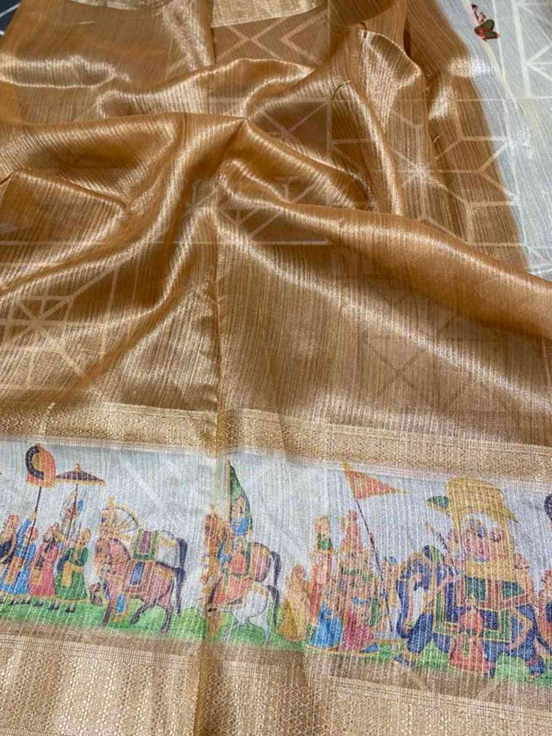 Close-up of gold zari tissue saree with festive prints