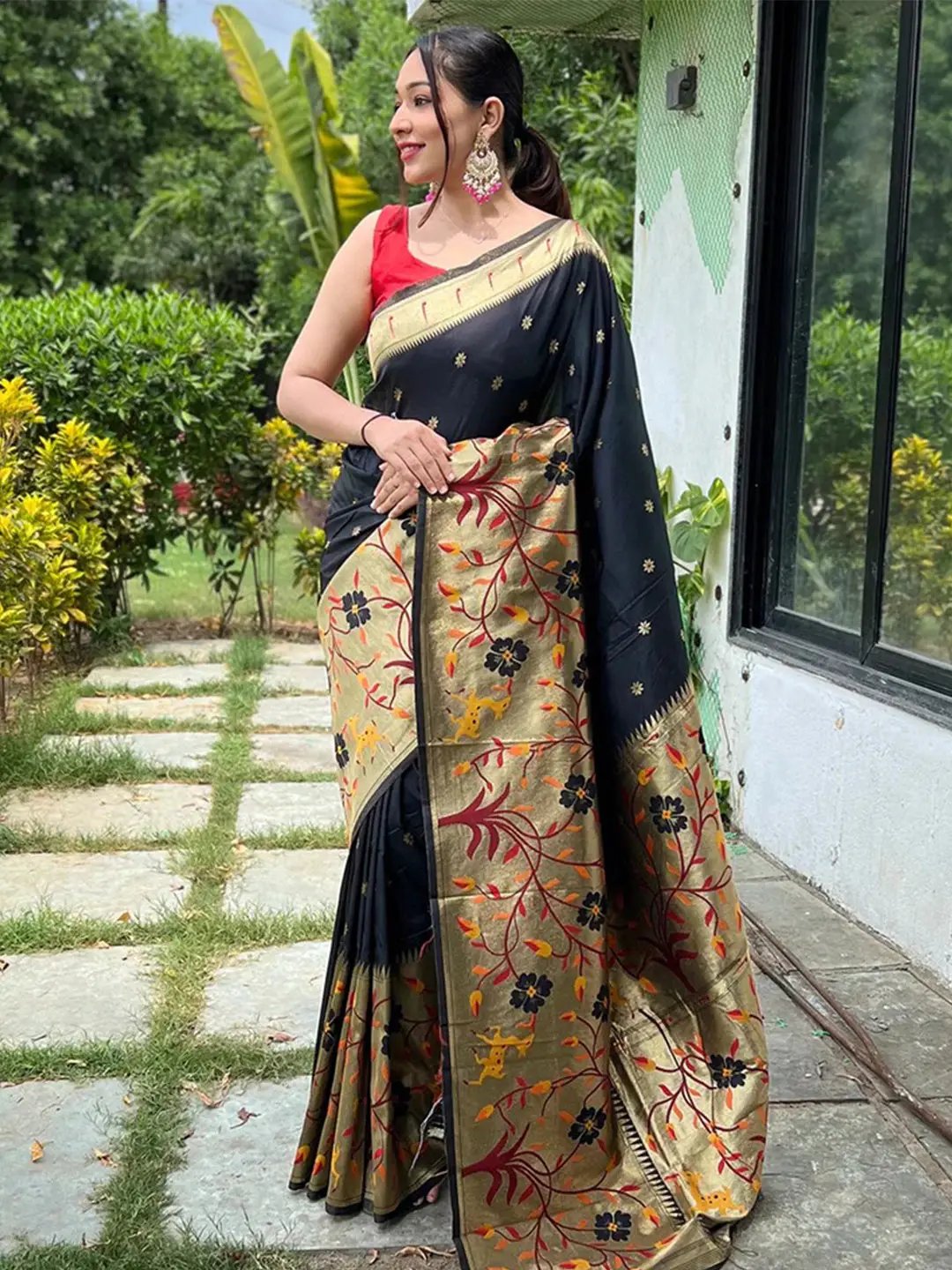 Elegant black Paithani saree with big border, worn by a woman outdoors