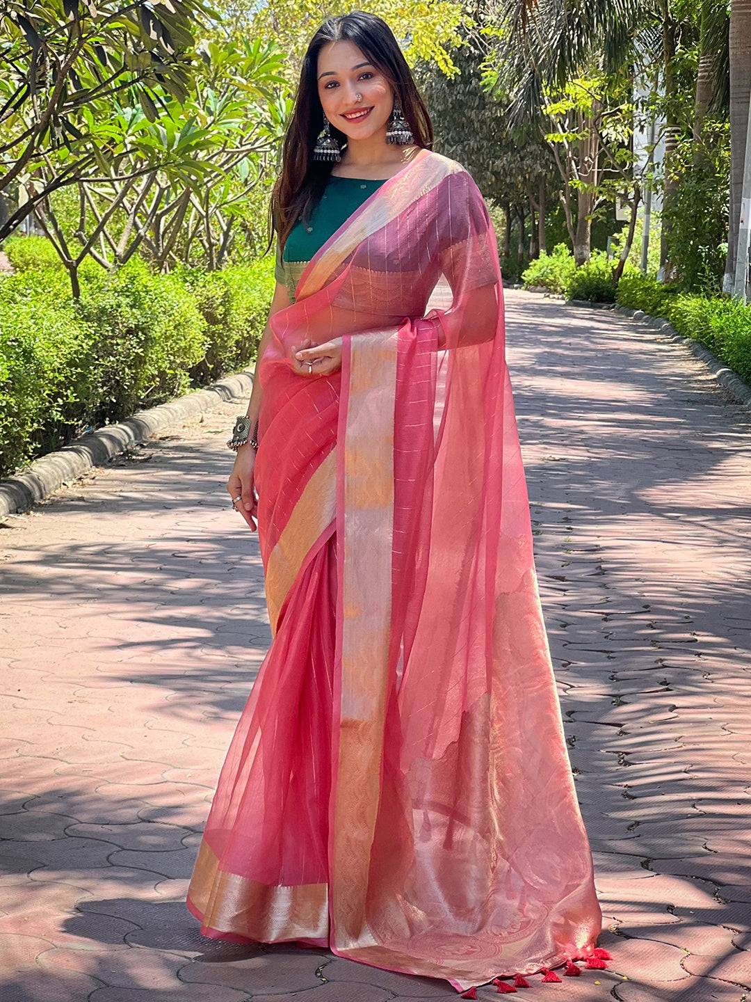 Model in dark pink organza saree with fine gold zari weaving.