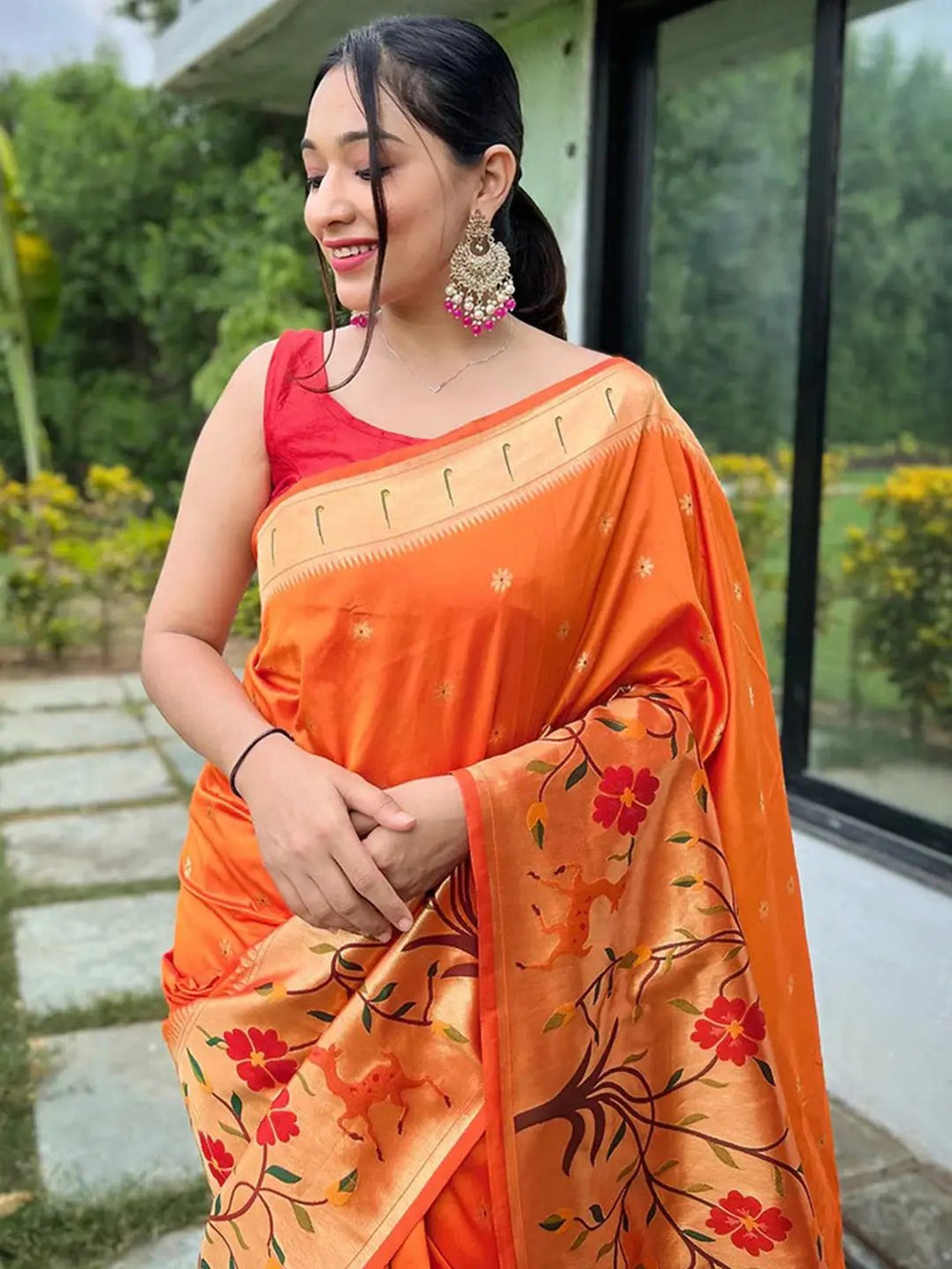 Close-up of orange Paithani saree with intricate floral border