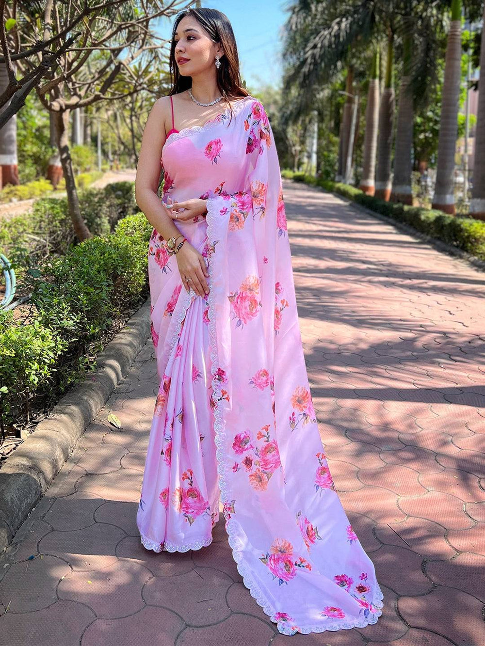 Elegant pink georgette saree with floral design and zircon border