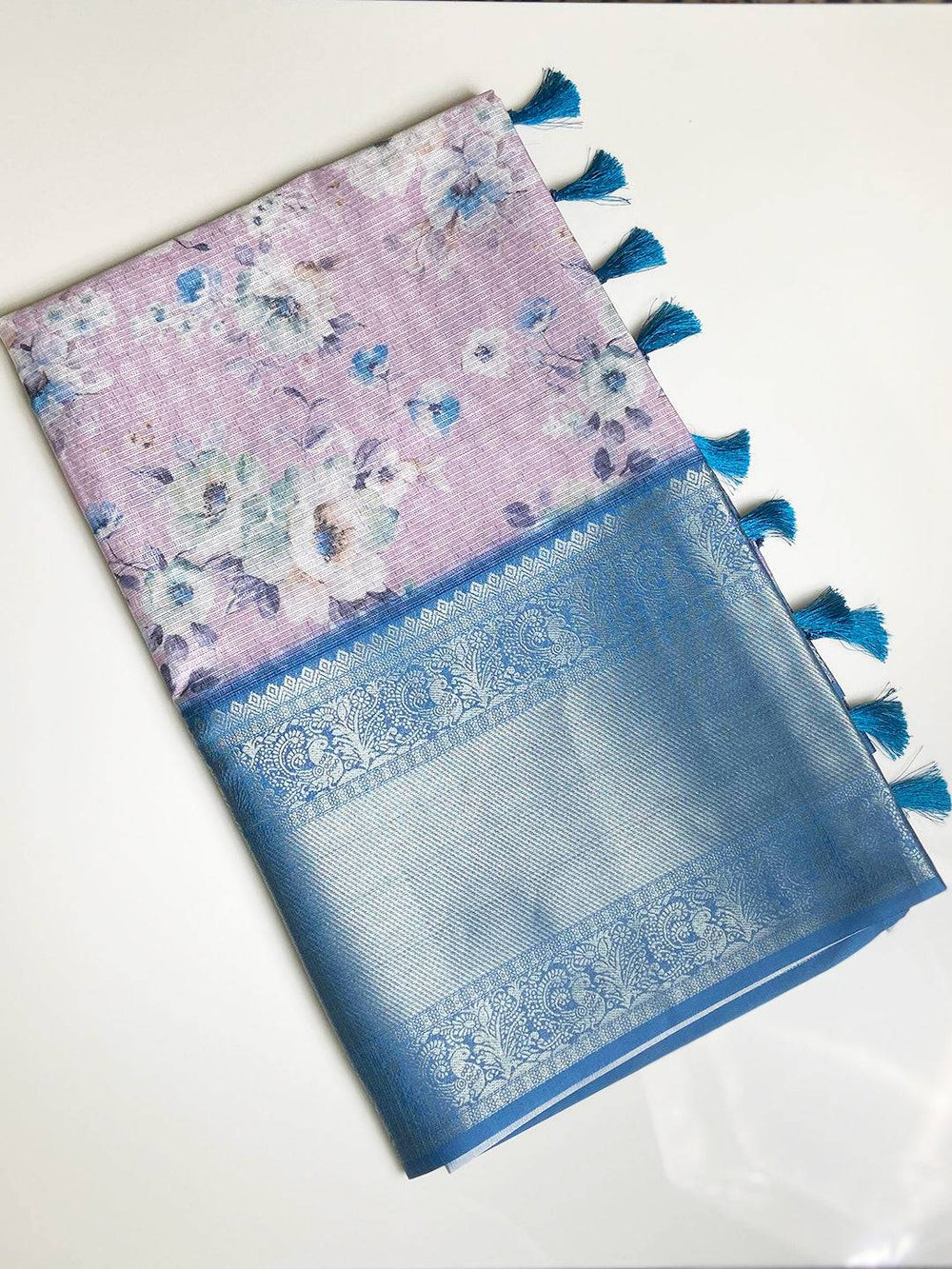 Folded floral saree with blue zari border and tassels
