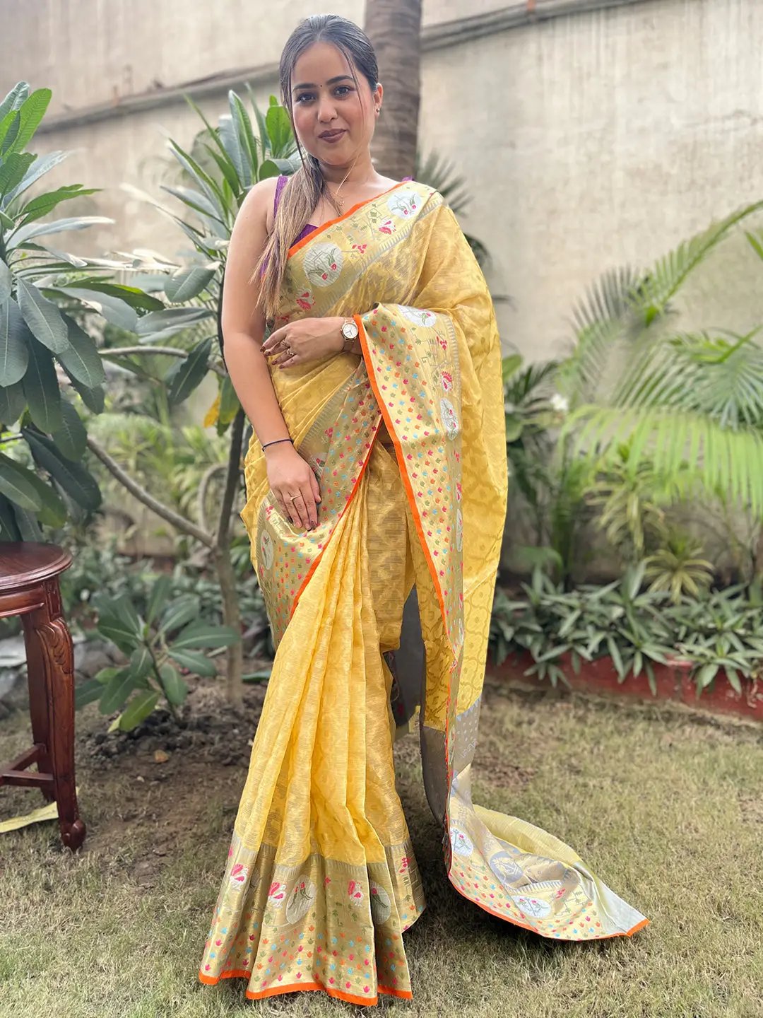 Model wearing elegant yellow Kota Doria silk saree outdoors