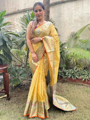 Model wearing elegant yellow Kota Doria silk saree outdoors