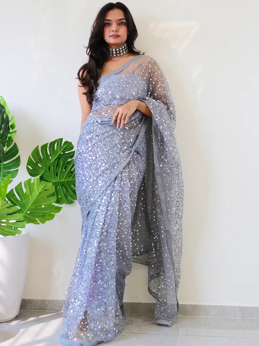 Elegant net saree with sequins embroidery, worn by a model.
