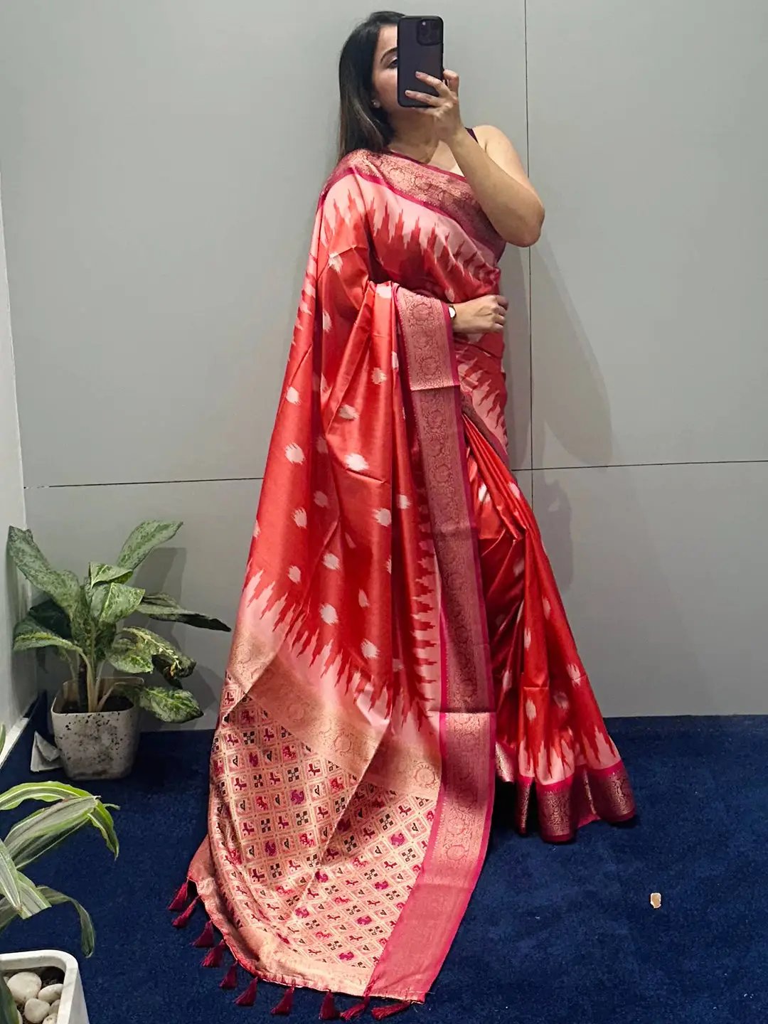 Red Banarasi saree with Zari Patola pallu displayed indoors
