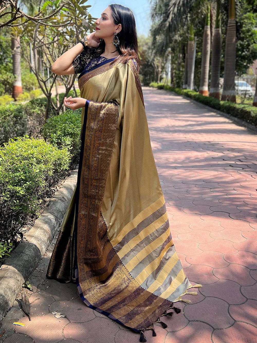 Model showcasing olive Kanjivaram saree with rich patterns