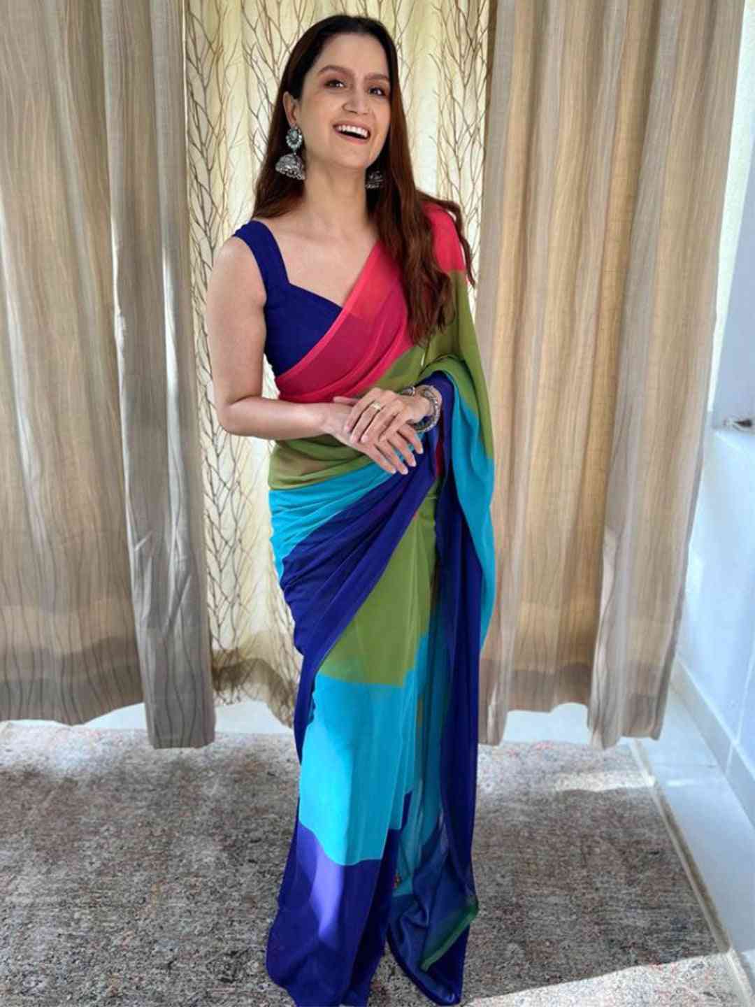 Woman in vibrant ombre saree with pink, blue, and green hues
