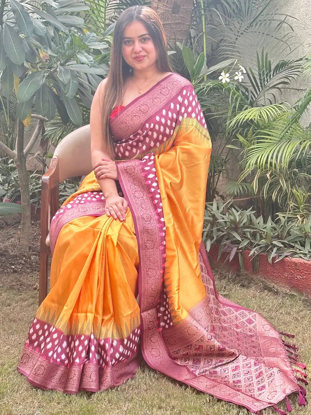 Woman in Pure Banarasi Soft Silk Saree with Patola Pallu seated outdoors