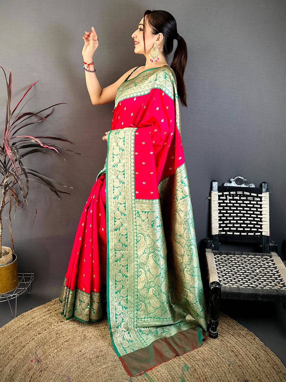 Close-up of bright pink silk saree with gold zari border and small gold motifs