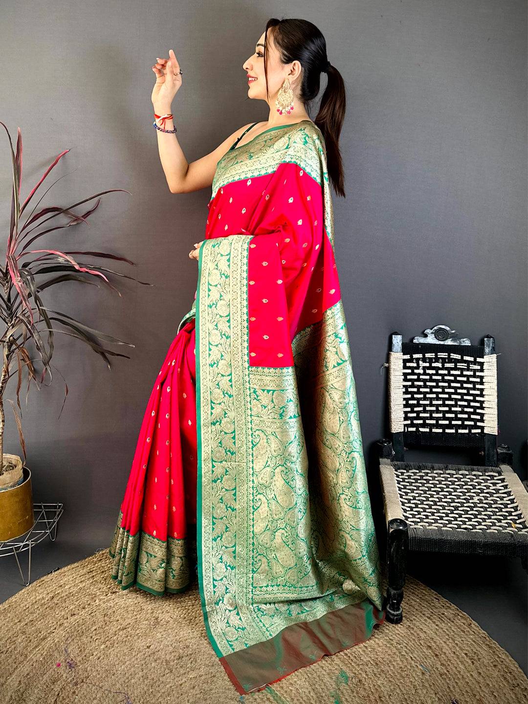 Close-up of bright pink silk saree with gold zari border and small gold motifs