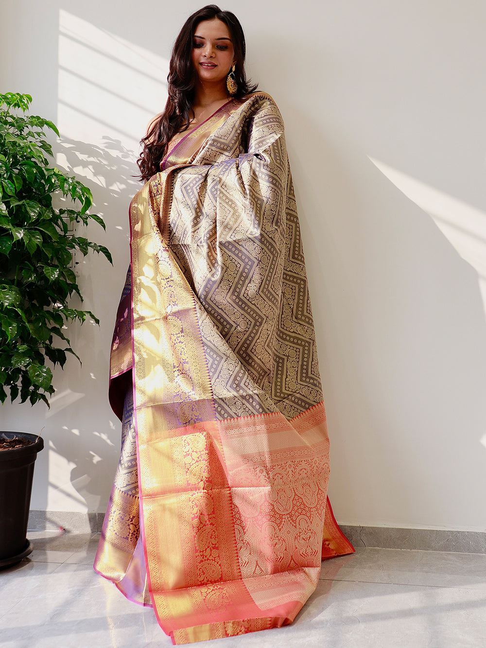 Gold zari Kanjivaaram pattu silk saree with intricate patterns.