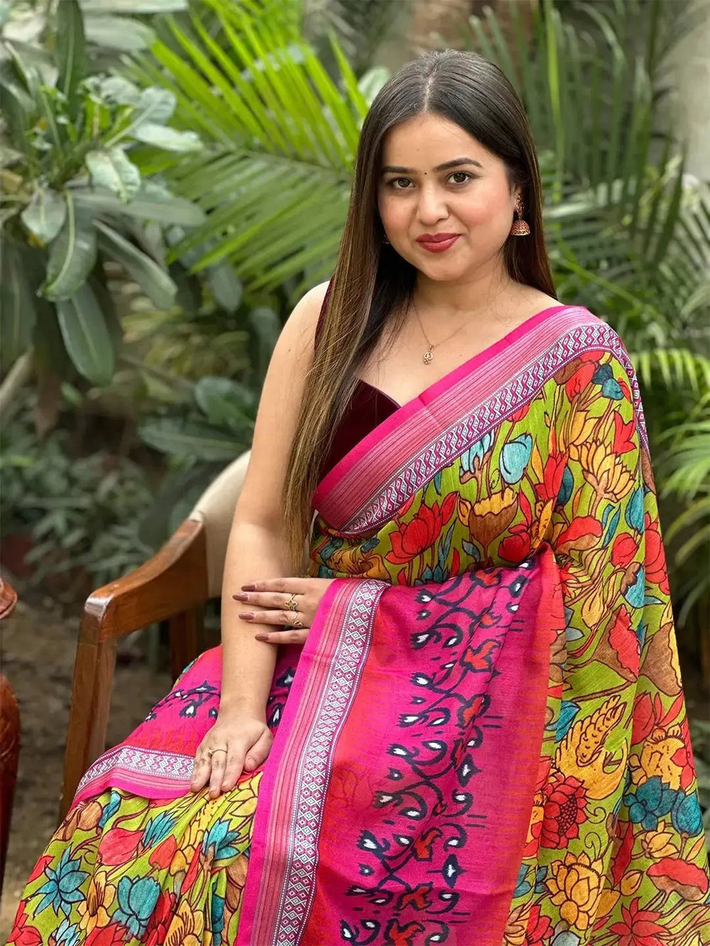 Close-up of floral Ikkat saree with pink border, seated