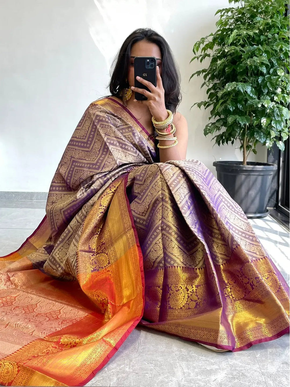 Model showcasing gold zari Kanjivaaram saree in vibrant hues.