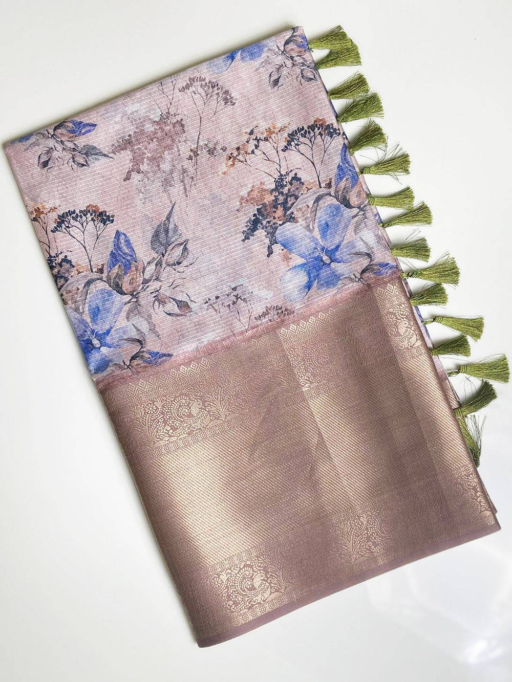 Folded light pink saree with floral design and gold zari border