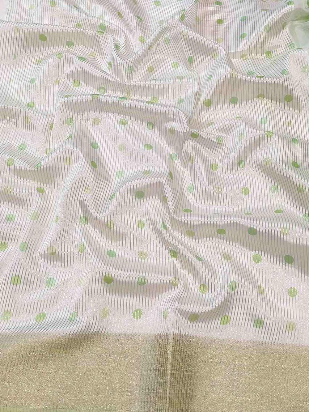 Detailed view of organza saree with green polka dots
