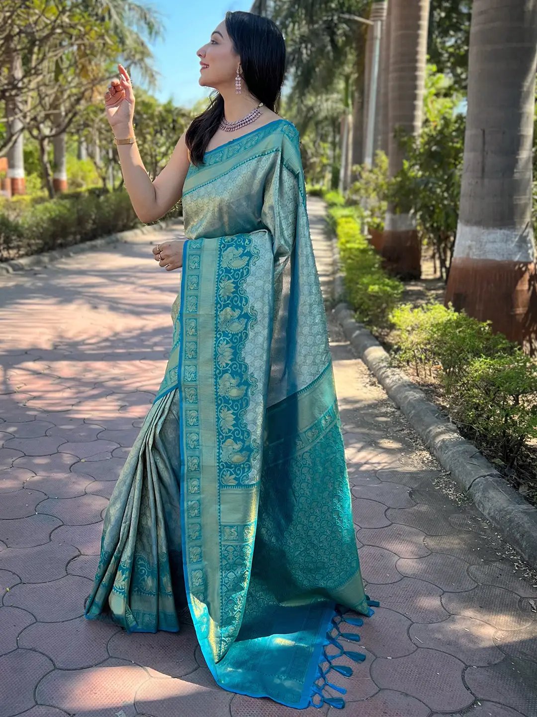 Woman posing in traditional Kanjivaram silk saree on pathway