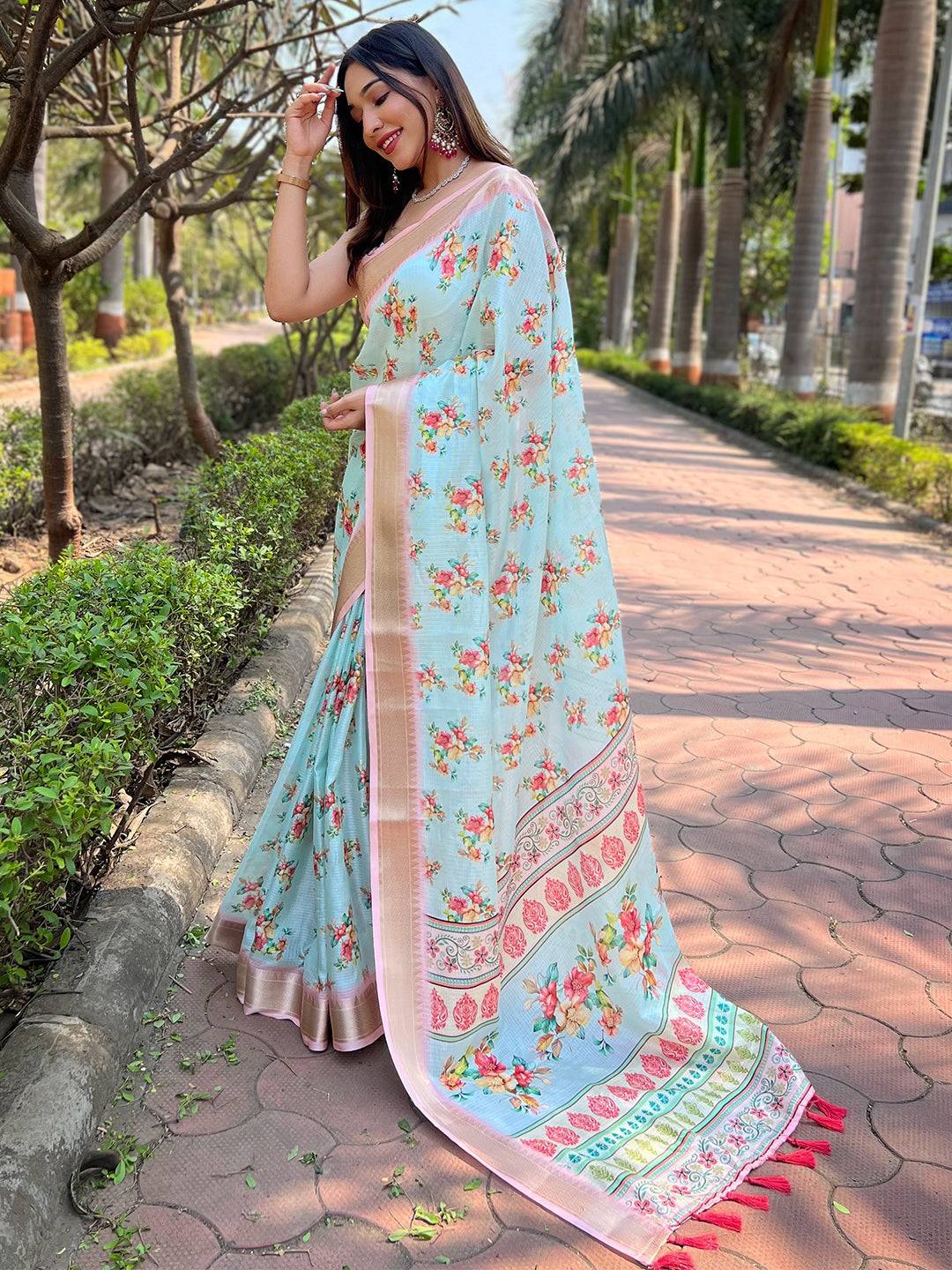 Model showcasing turquoise Kota saree with floral design.