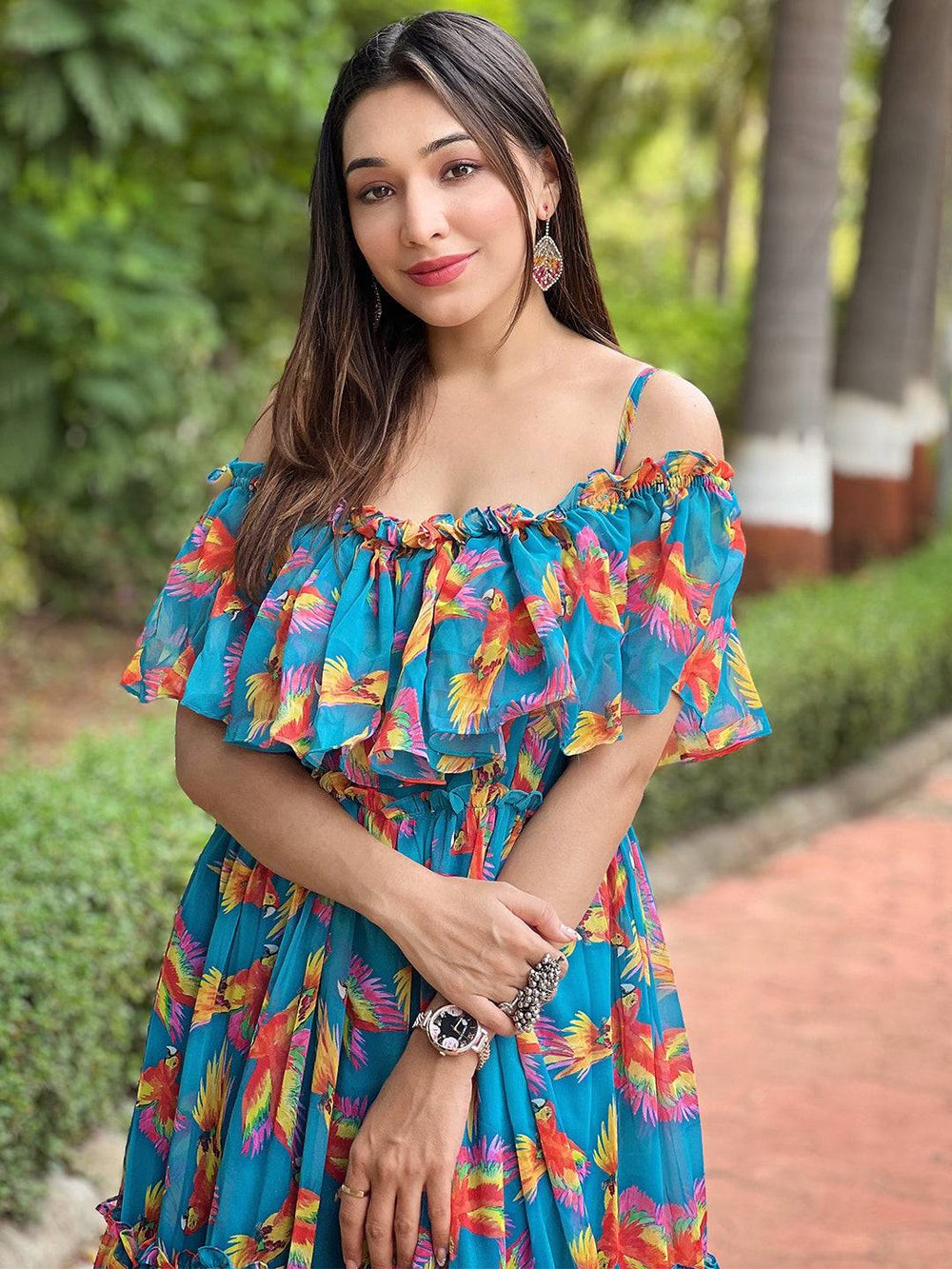 Model in blue maxi dress with colorful bird pattern