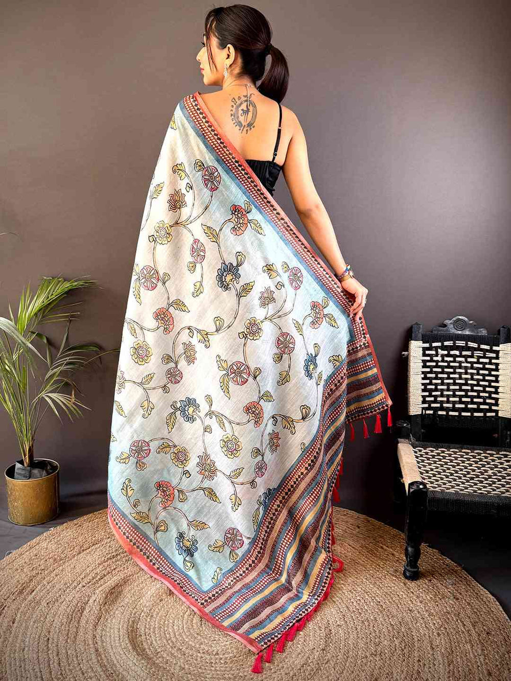 Back view of Sky Blue Zari Tussar Floral Saree showcasing its exquisite floral patterns and contrasting border with tassel details.