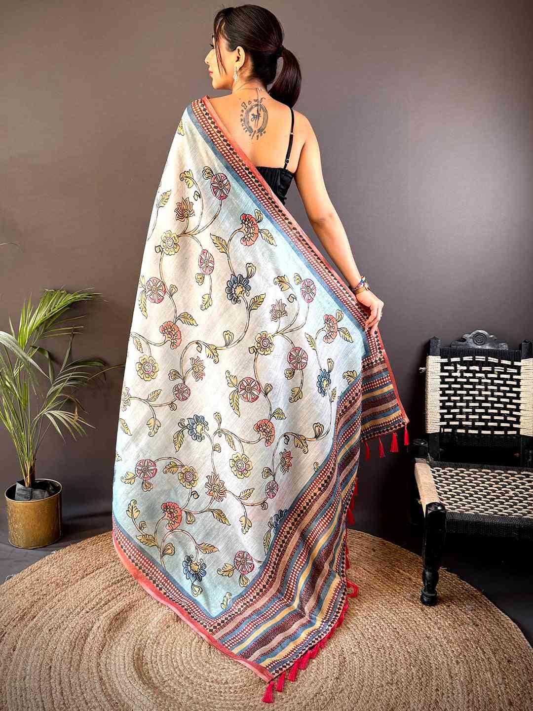 Back view of Sky Blue Zari Tussar Floral Saree showcasing its exquisite floral patterns and contrasting border with tassel details.
