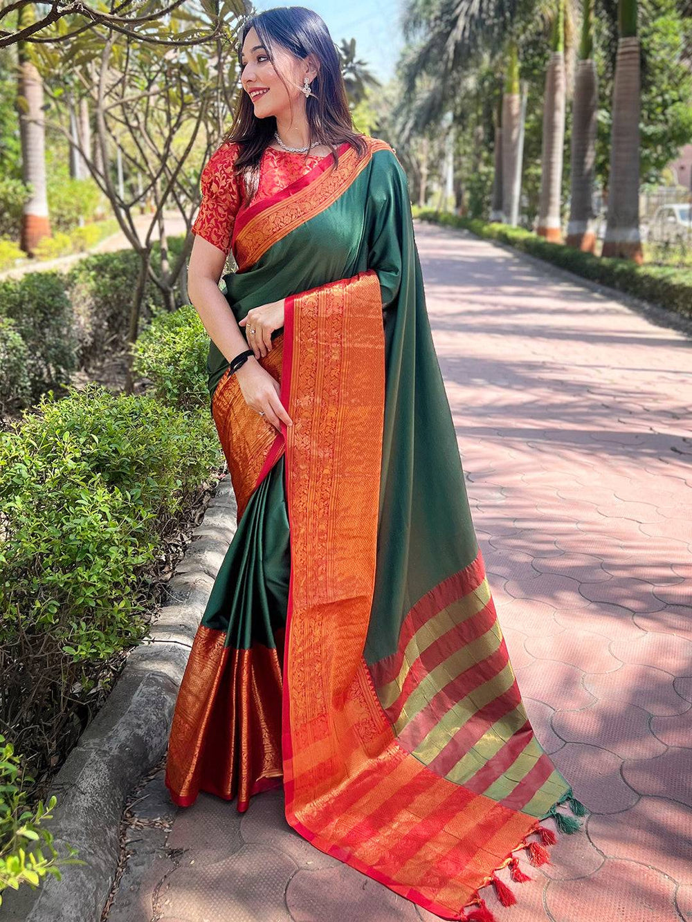 Model wearing bottle green Kanjivaram saree with intricate border
