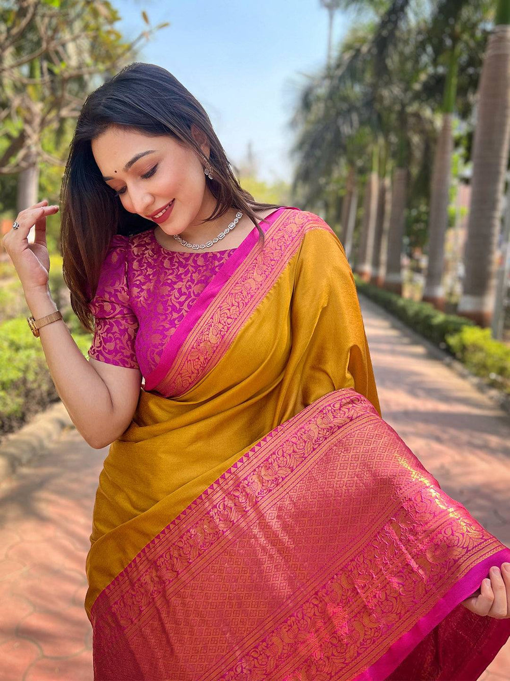 Model in Aura soft silk mustard saree with pink Kanjivaram border