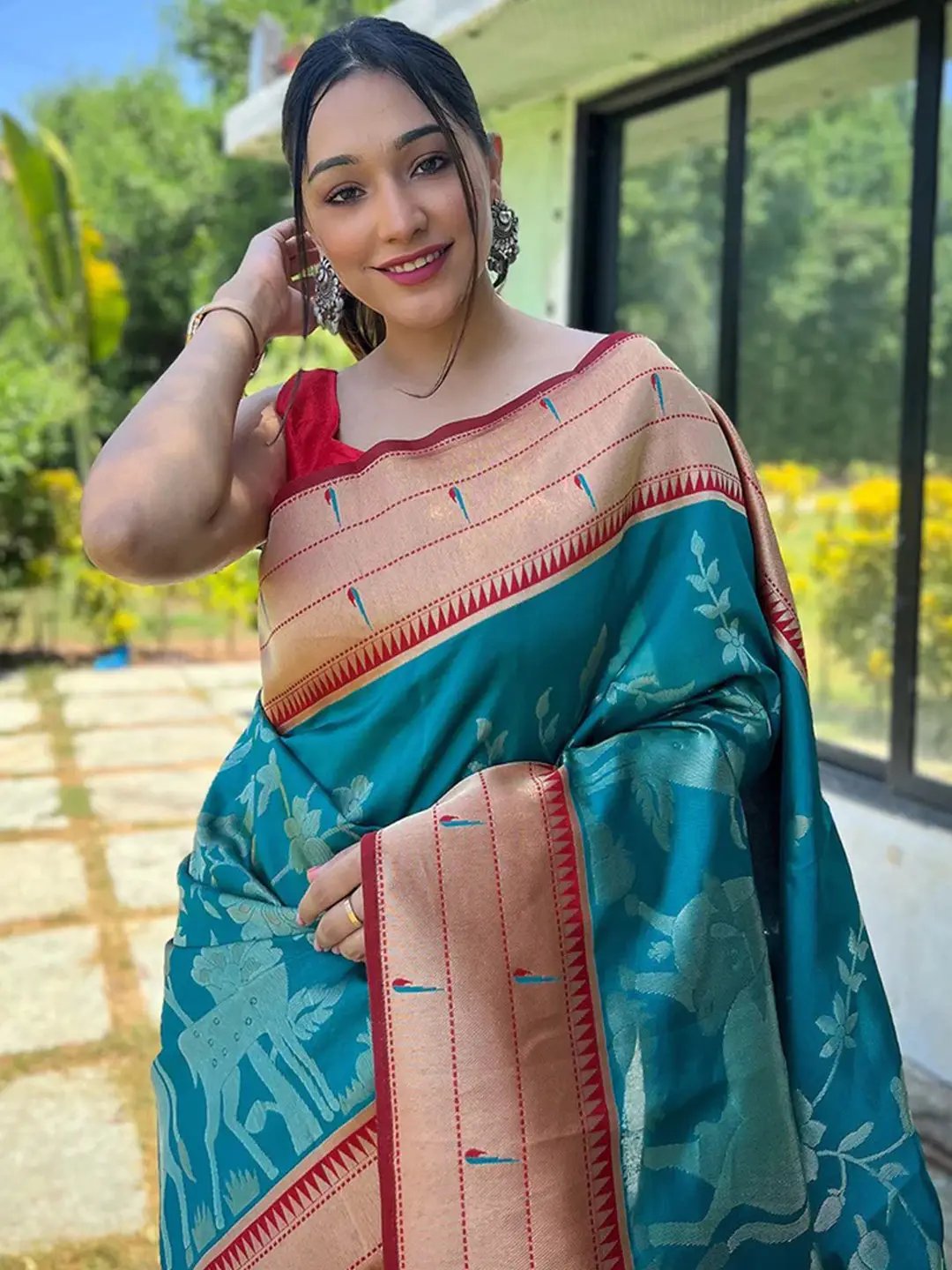 Woman wearing teal Paithani silk saree with intricate pichwai design