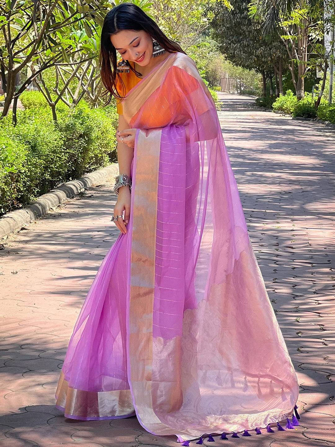 Elegant purple saree with gold zari border, outdoor setting