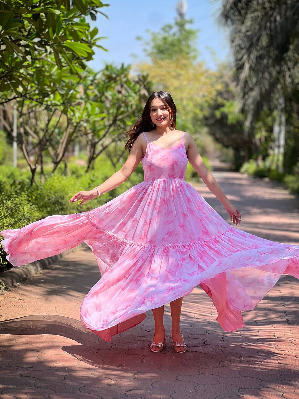 Model showcasing flowing blush pink batik dress in garden
