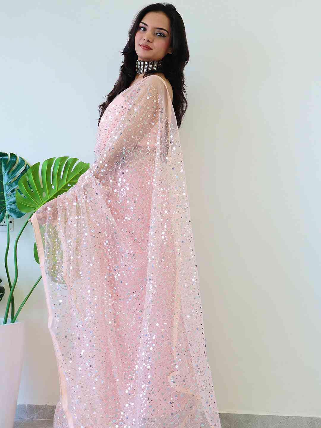 Elegant net saree with shimmering sequins, side view.