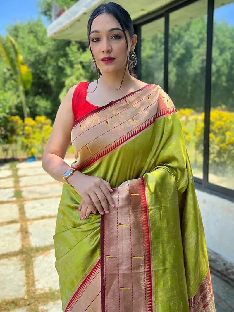 Lime green Paithani silk saree with red blouse, worn outdoors.