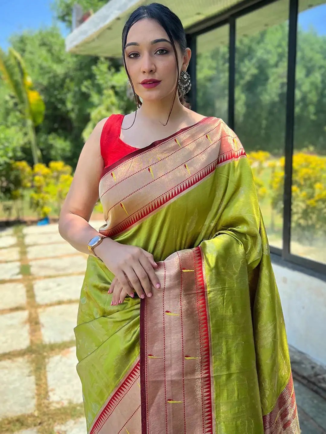 Lime green Paithani silk saree with red blouse, worn outdoors.