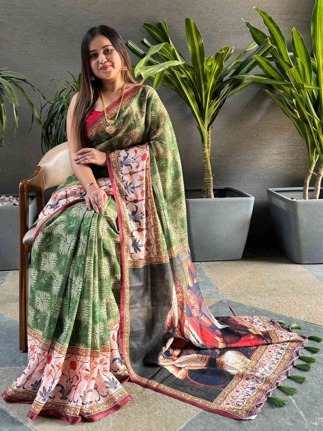 Green saree with kalamkari print pallu, seated model