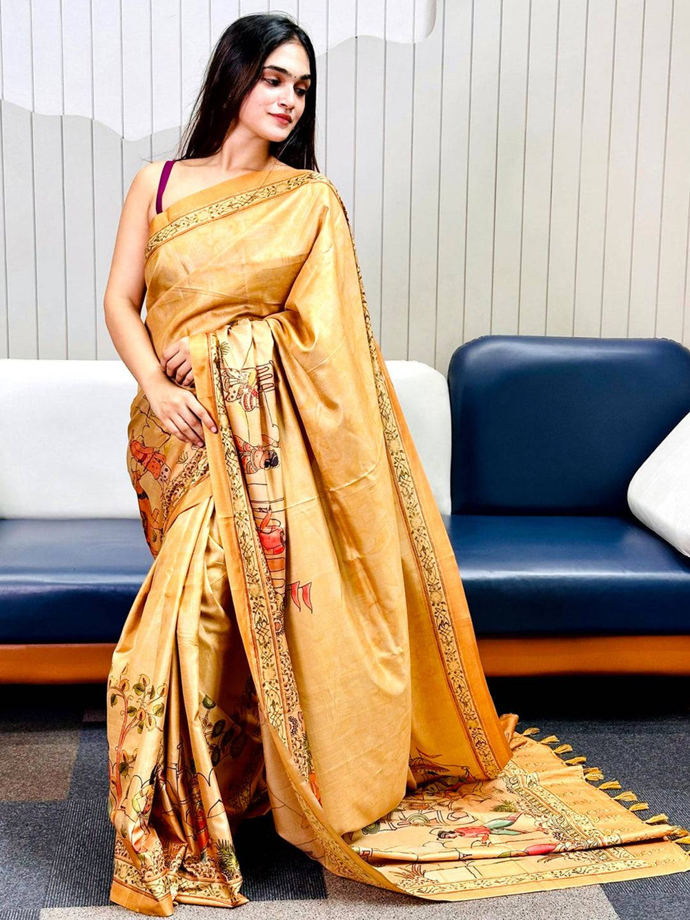 Model showcasing a gold Kalamkari saree with exquisite free hand prints.