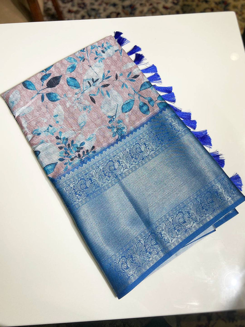 Folded Muvel Kota Doriya saree with blue floral design and tassels
