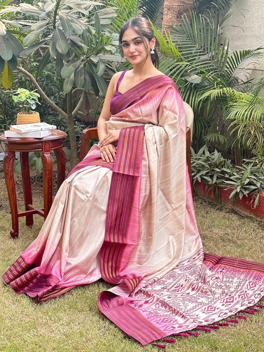 Woman in wine Ikkat Ghicha saree sitting outdoors