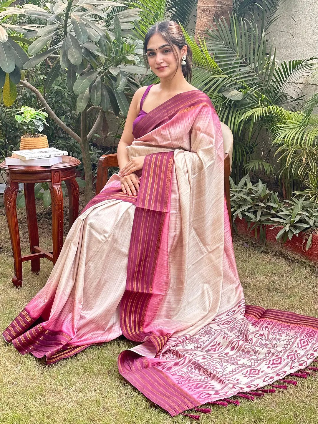 Woman in wine Ikkat Ghicha saree sitting outdoors