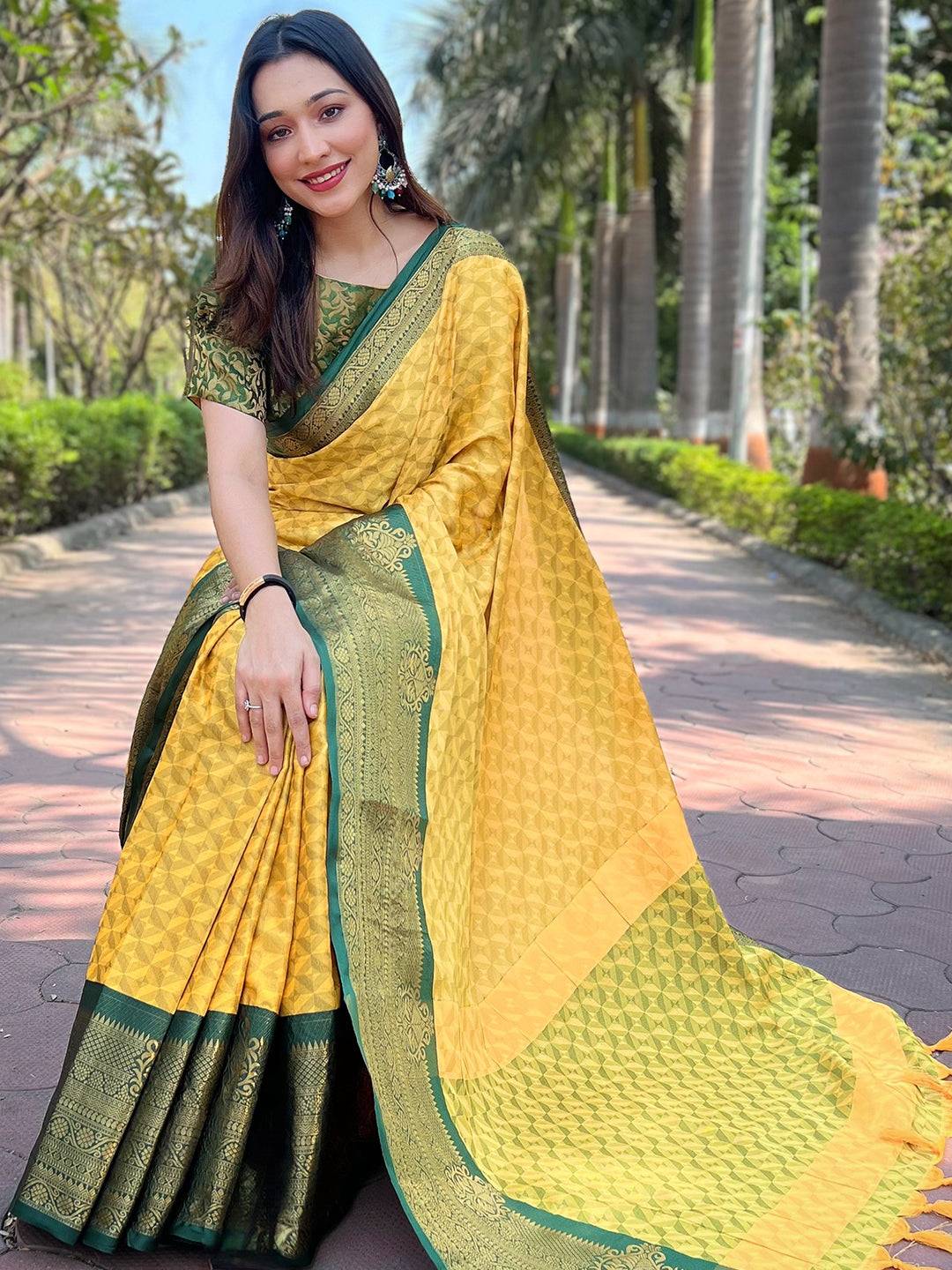 Seated woman in yellow Kanjivaram saree with green details