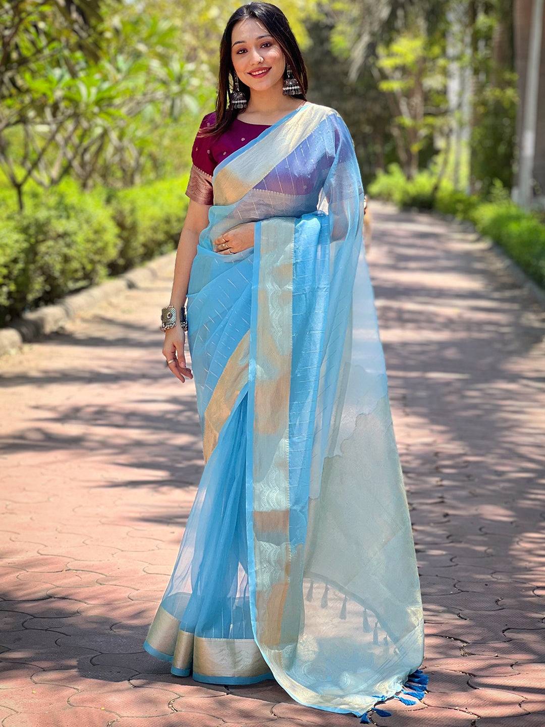 Model in blue organza saree with intricate gold zari border
