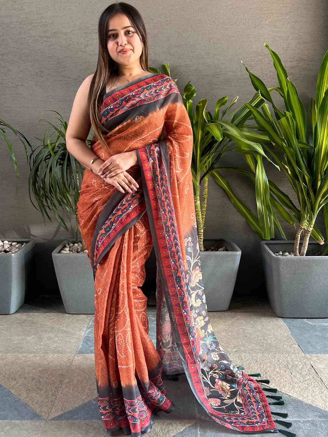 Model in orange Bandhani saree with Kalamkari border, standing