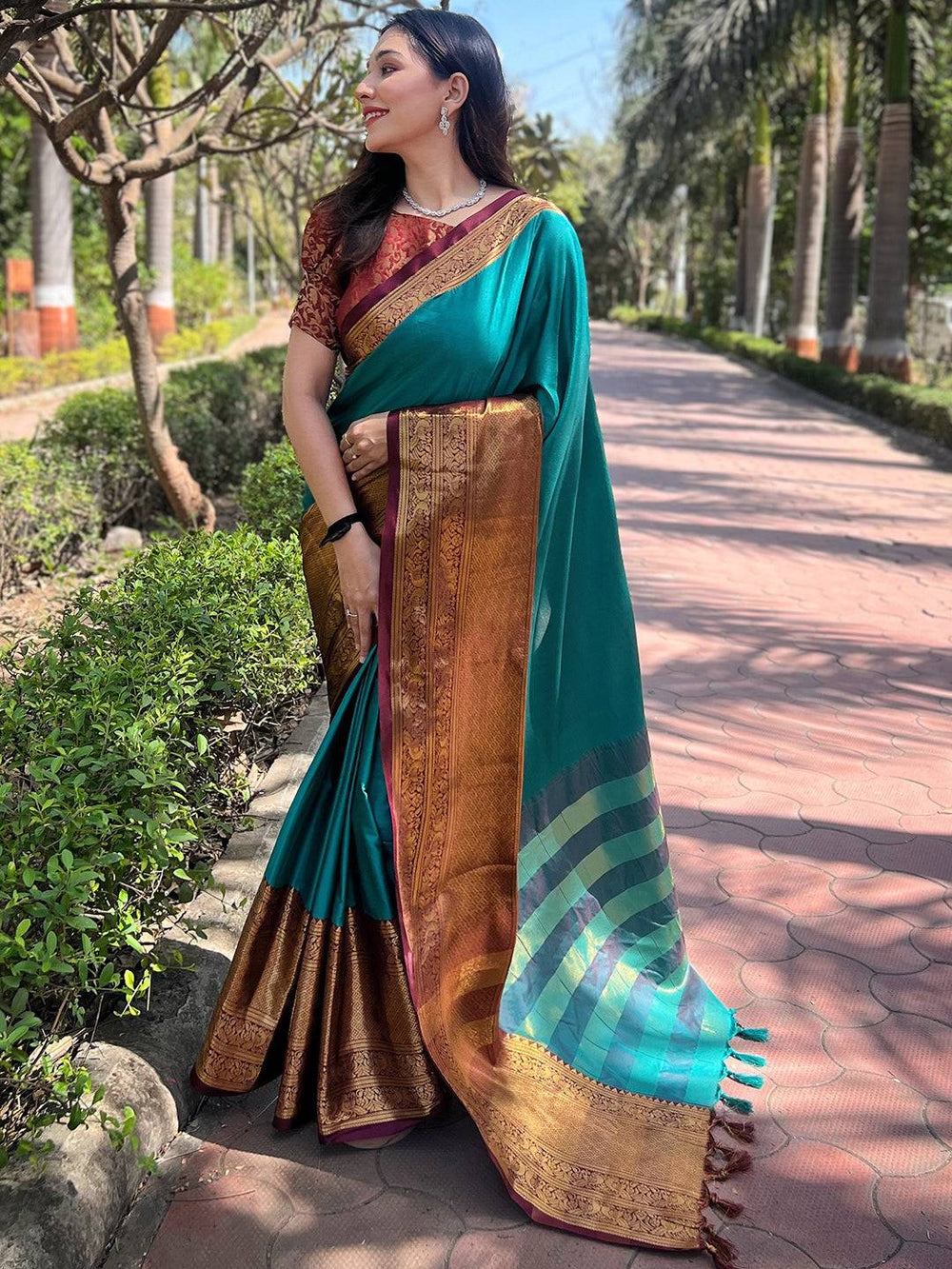 Teal Kanjivaram saree with gold border and intricate design