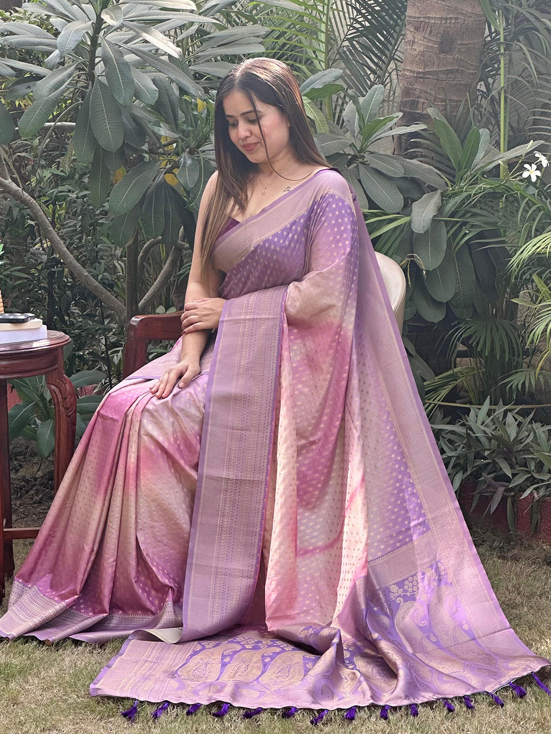 Woman seated in violet ombre Banarasi saree outdoors