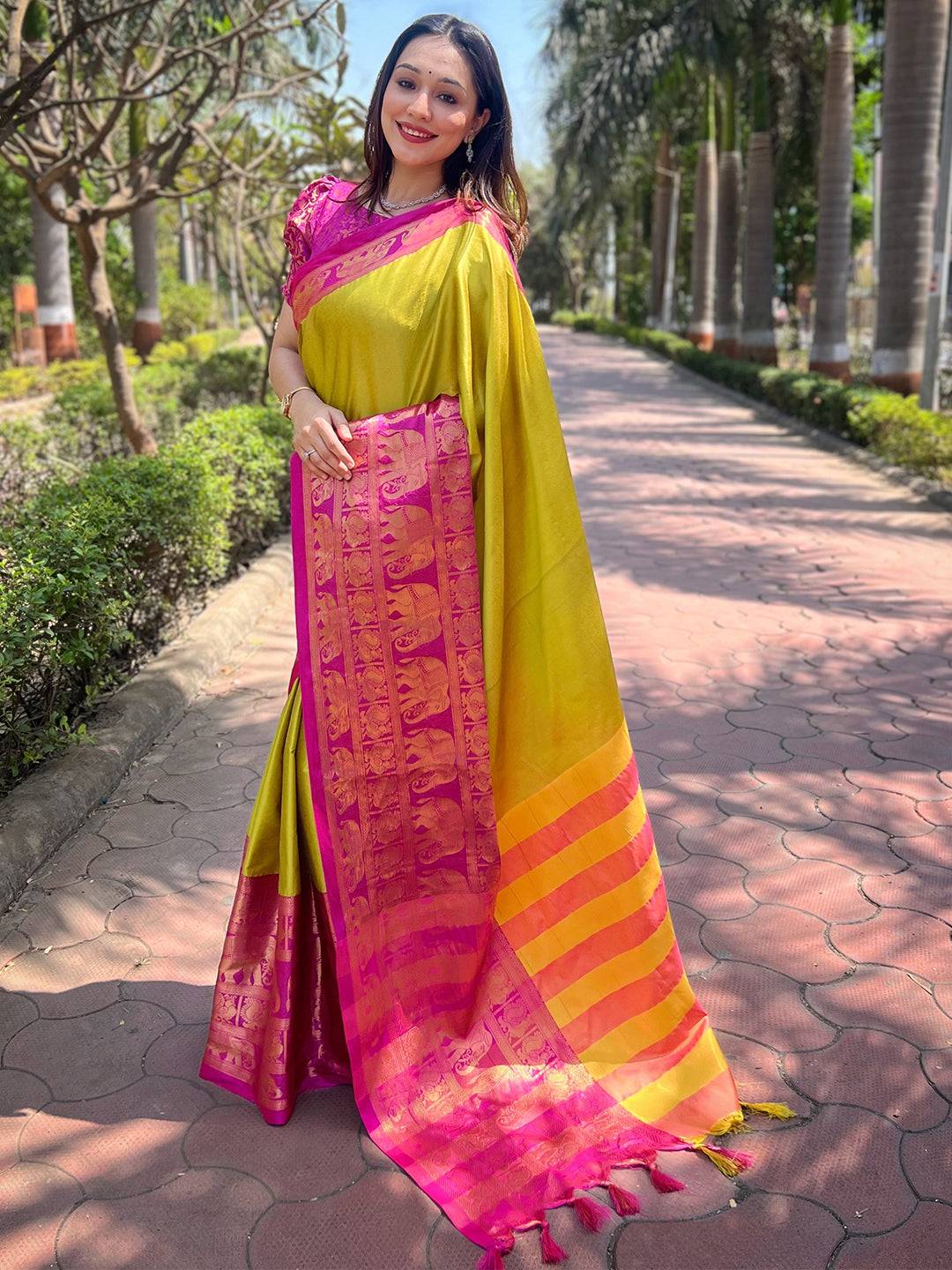 Model wearing light green saree with intricate pink designs