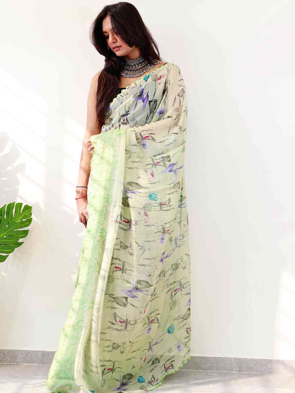 Chiffon satin saree featuring floral prints and intricate green border.