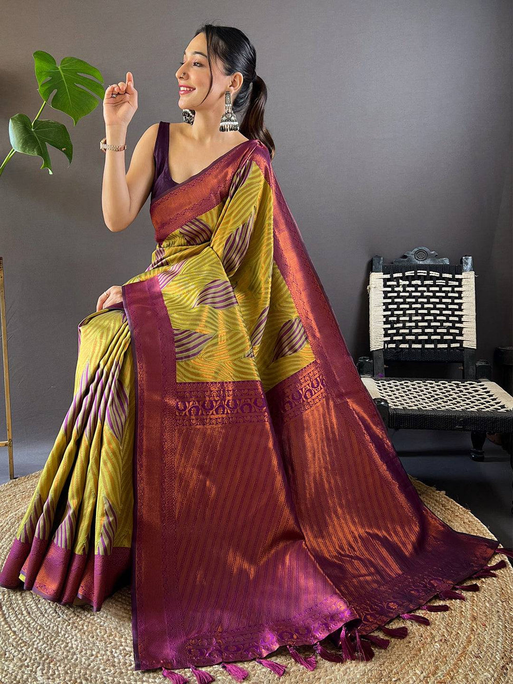 Model sitting in green tussar silk ikkat saree with zari details